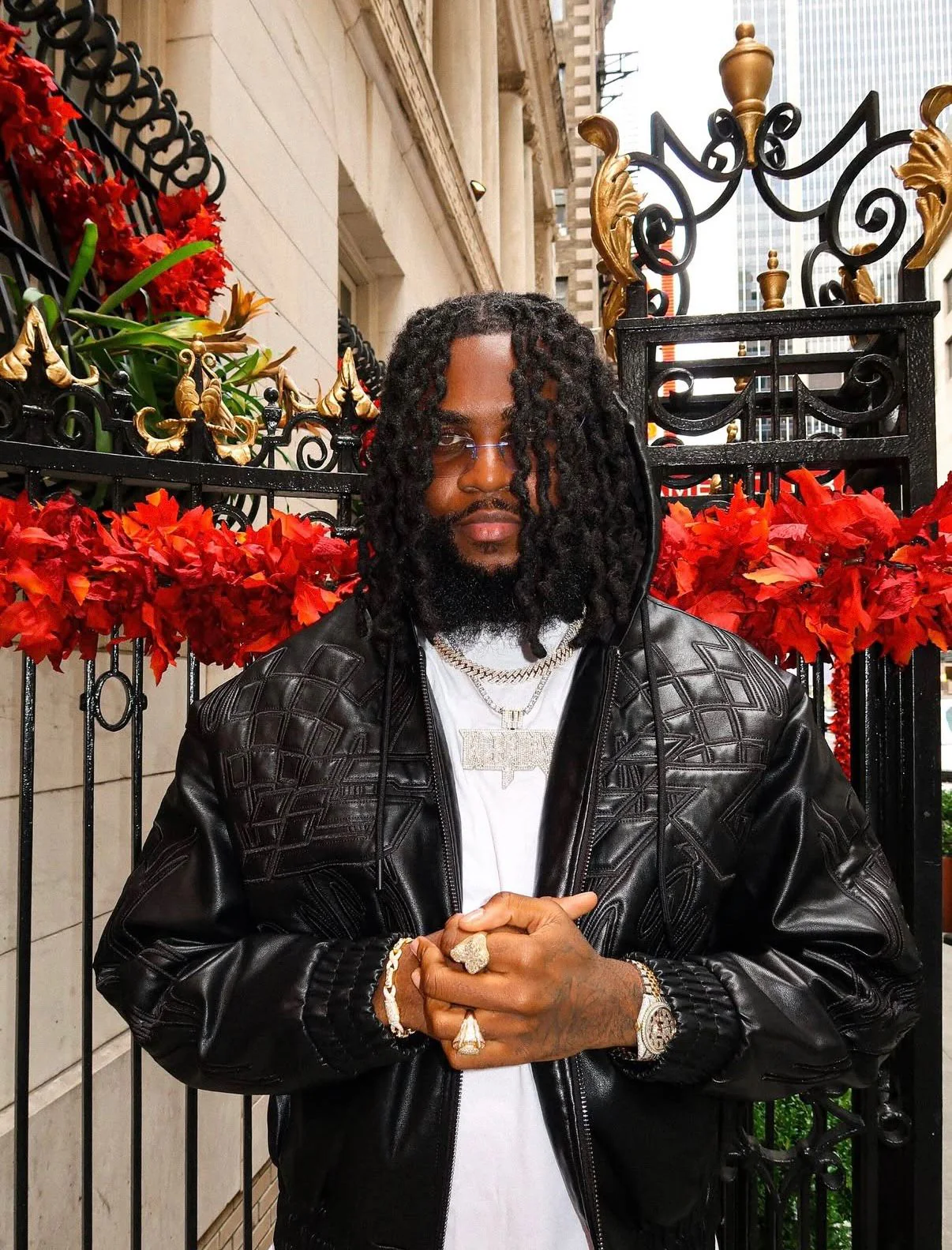 Producer Weekday wearing a black leather jacket in an urban setting with red floral decorations.